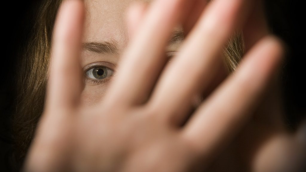 A woman's hands in front of her face.