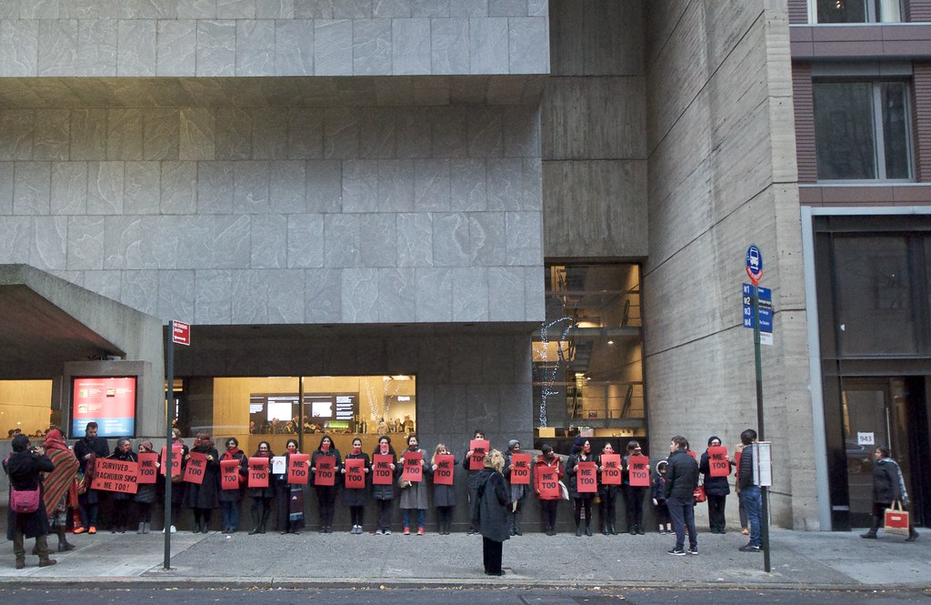 Women outside of a protest holding "Me Too" signs