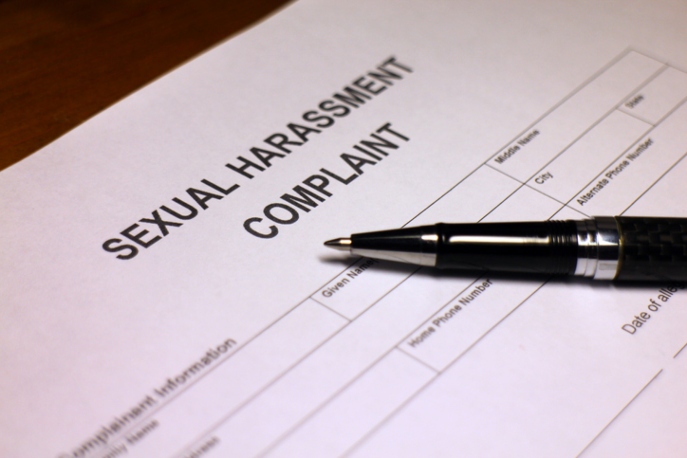 Sexual Harassment Complaint document with black pen.