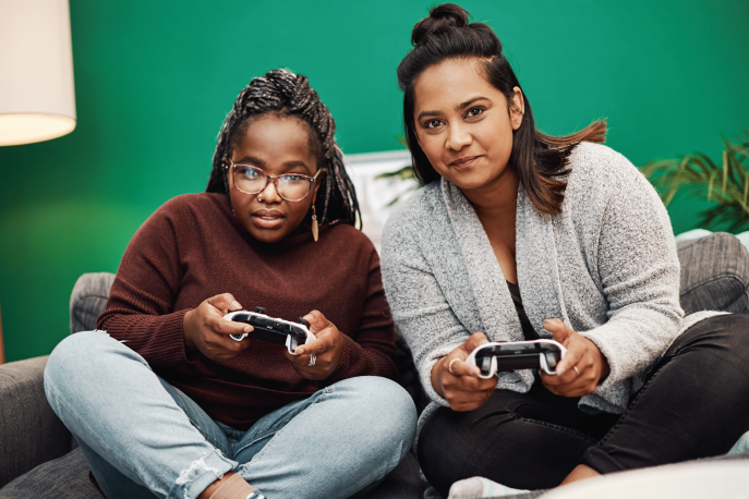 Two women of color playing a video game