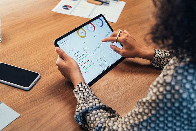 Woman looking at graphs and data on a tablet