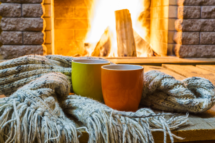 Two mugs in front of a fireplace