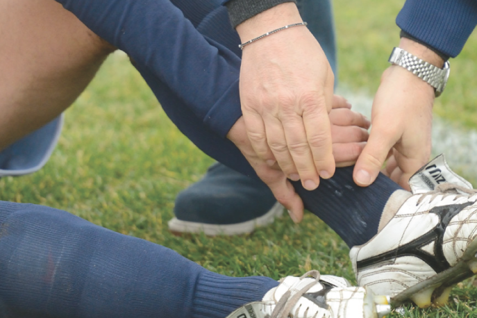 Athletic trainer helping an injured athlete