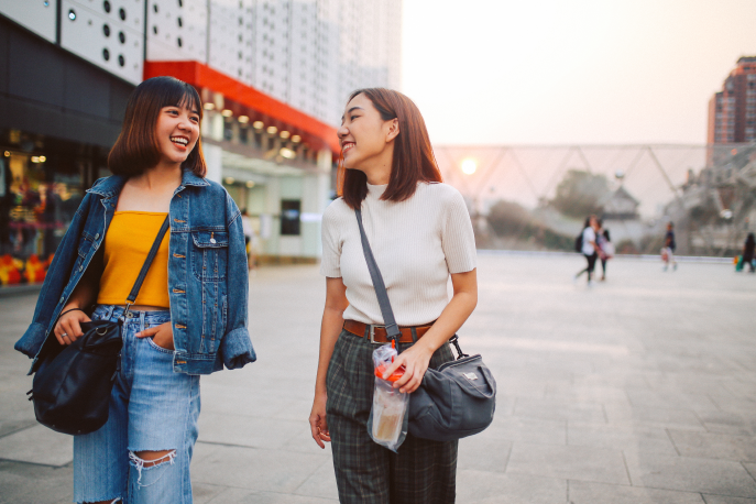 Two Asian American women walking down the street