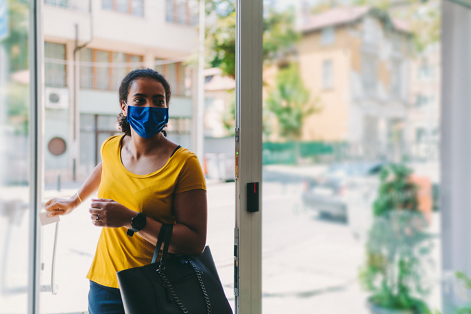 Woman wearing a face mask entering a building