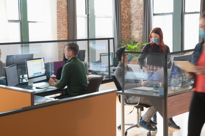 People wearing masks working in an open-plan office