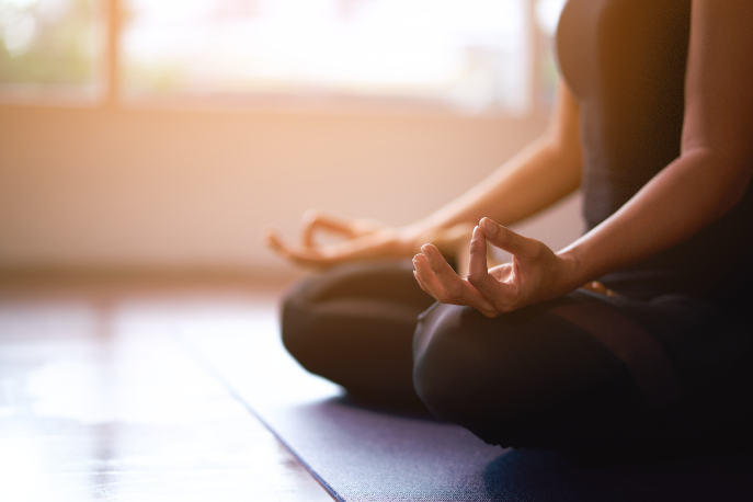 Person sitting on the floor meditating