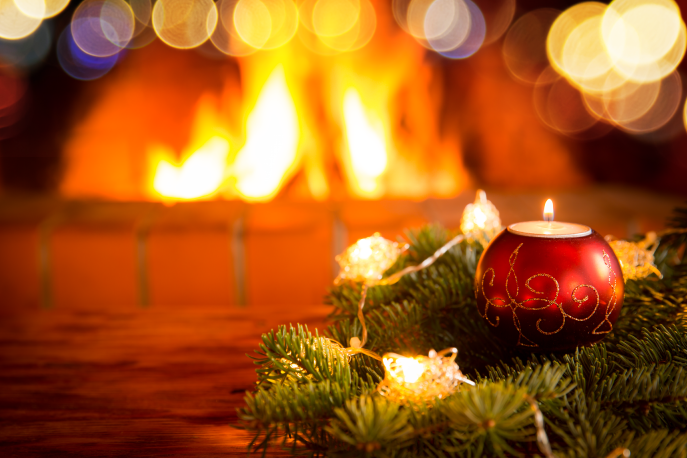 Candle in front of a fireplace