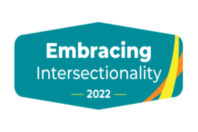 Six-sided teal shape of NSAC logo with text that reads "Embracing Intersectionality -2022-" and criss-crossing orange and yellow stripes on left-hand side of shape.