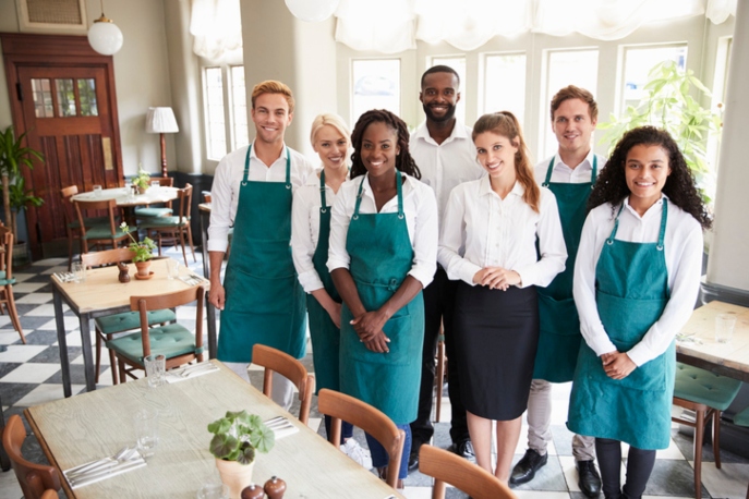 Diverse restaurant staff standing together and smiling at the camera.