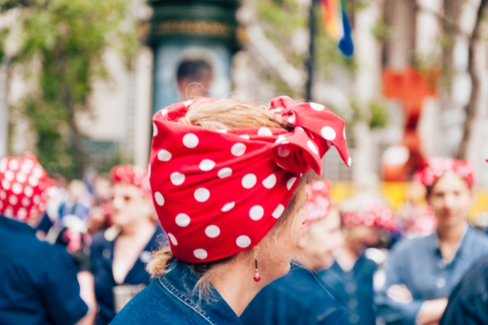 Faceless crowd of women dressed as Rosie the Riveter