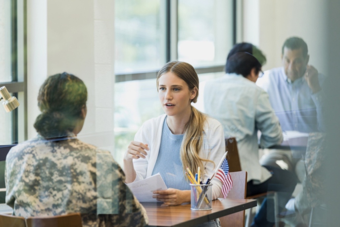 Young Woman Speaking to a Veteran in an Office Setting