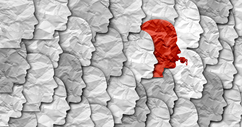 Crumbled paper silhouettes of heads, one of them red blowing a whistle
